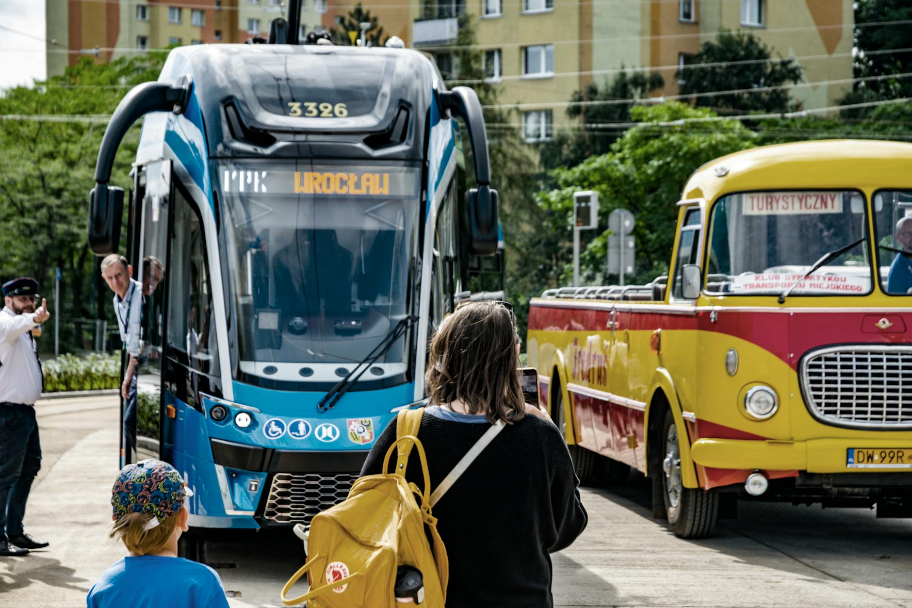 Ilustracja przedstawiająca nowoczesny autobus elektryczny na tle miasta Mrągowo, symbolizujący inwestycję w transport publiczny.